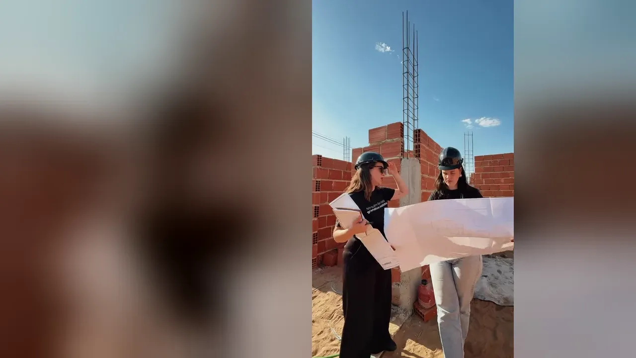 As arquitetas da Albernaz com capacete de obra, analisando a planta em um canteiro